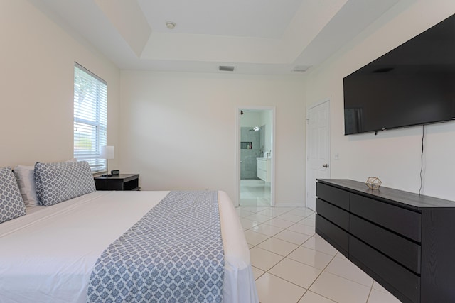 541 NW Pine Sap Pl, Jensen Beach, FL 34957 - bedroom featuring light tile patterned floors, a tray ceiling, and connected bathroom