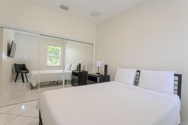 541 NW Pine Sap Pl, Jensen Beach, FL 34957 - bedroom featuring a closet, light tile patterned floors, and baseboards