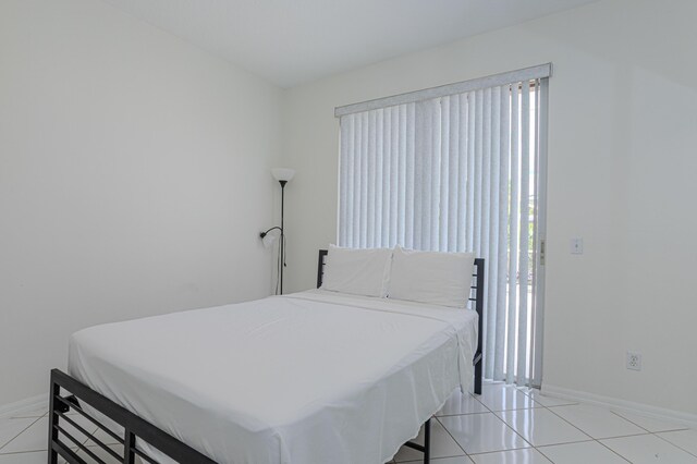 541 NW Pine Sap Pl, Jensen Beach, FL 34957 - bedroom with baseboards and light tile patterned floors