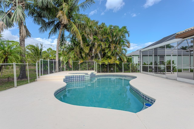 541 NW Pine Sap Pl, Jensen Beach, FL 34957 - view of swimming pool with a patio area, glass enclosure, and a pool with connected hot tub