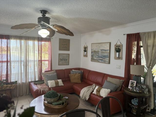 6207 Adriatic Way, West Palm Beach, FL 33413 - tiled living area featuring ceiling fan, ornamental molding, and a textured ceiling