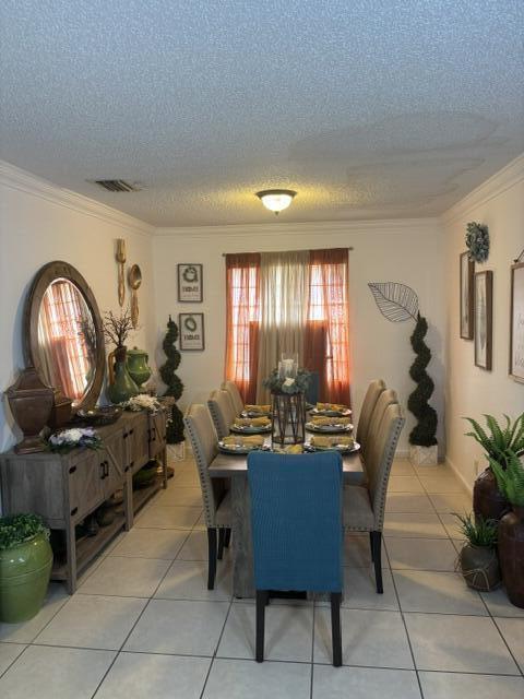 6207 Adriatic Way, West Palm Beach, FL 33413 - dining area with visible vents, a textured ceiling, ornamental molding, and light tile patterned flooring