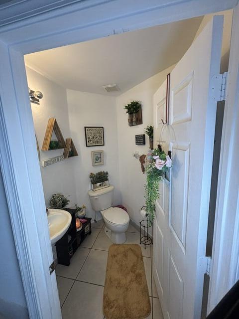 6207 Adriatic Way, West Palm Beach, FL 33413 - half bath with visible vents, tile patterned floors, a sink, and toilet
