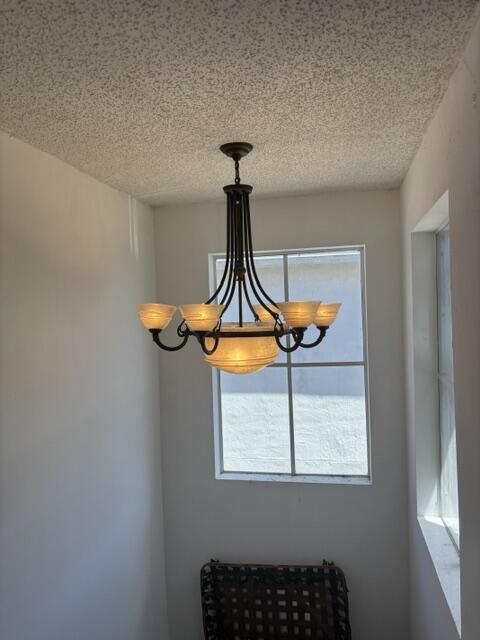 6207 Adriatic Way, West Palm Beach, FL 33413 - interior details featuring an inviting chandelier and a textured ceiling