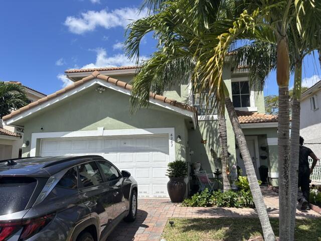 6207 Adriatic Way, West Palm Beach, FL 33413 - view of front of house with stucco siding, a tile roof, and an attached garage