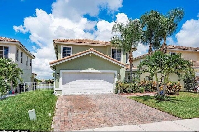 6207 Adriatic Way, West Palm Beach, FL 33413 - mediterranean / spanish-style home featuring fence, decorative driveway, a tiled roof, and a front yard