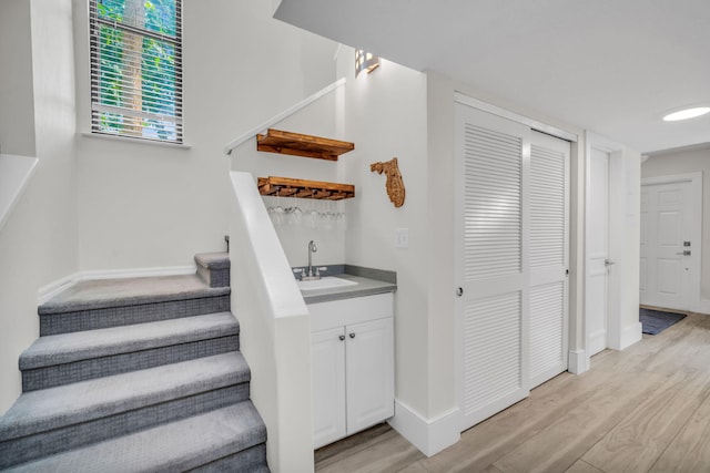 1330 NW 13th St Unit 6, Boca Raton, FL 33486 - staircase featuring wood finished floors, bar with sink, and baseboards