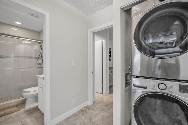 1330 NW 13th St Unit 6, Boca Raton, FL 33486 - washroom featuring stacked washer / drying machine, light tile patterned floors, and a textured ceiling