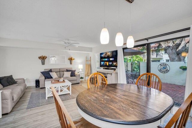 dining space with baseboards, light wood finished floors, and ceiling fan