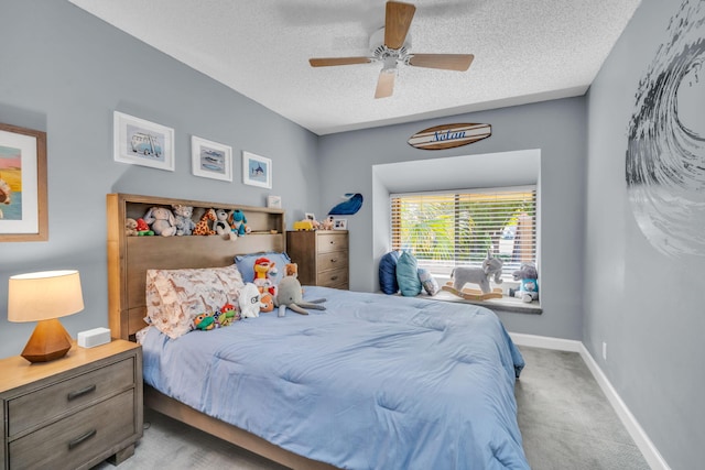 carpeted bedroom featuring baseboards, a ceiling fan, and a textured ceiling