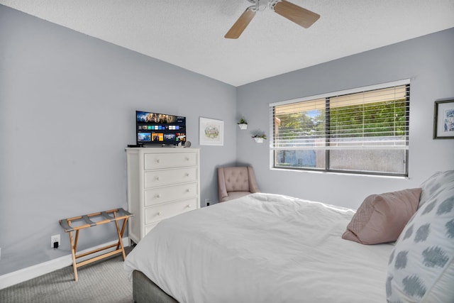 carpeted bedroom featuring baseboards, ceiling fan, and a textured ceiling