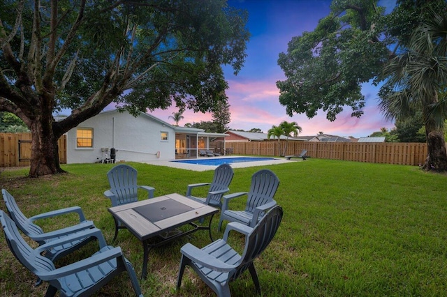 509 Oak Ter, Jupiter, FL 33458 - yard at dusk featuring a fenced backyard, a sunroom, and a fenced in pool