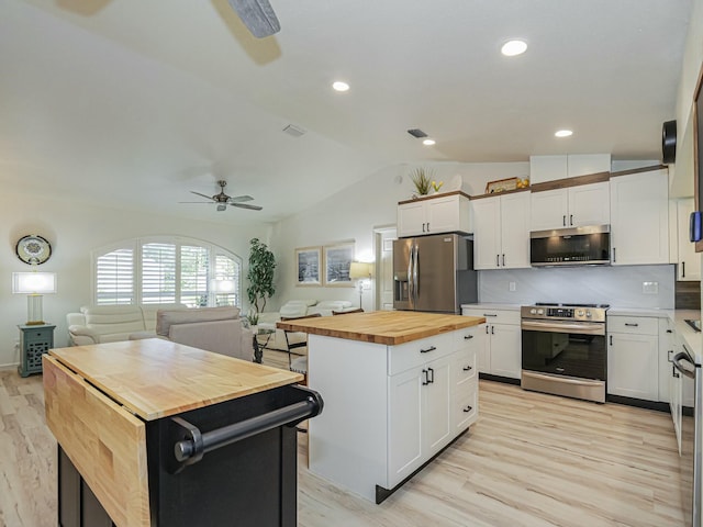 1732 Sunrise Ln, Sebastian, FL 32958 - kitchen with vaulted ceiling, a center island, wood counters, open floor plan, and appliances with stainless steel finishes