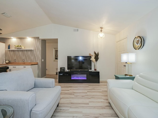 1732 Sunrise Ln, Sebastian, FL 32958 - living area featuring lofted ceiling, light wood finished floors, and visible vents