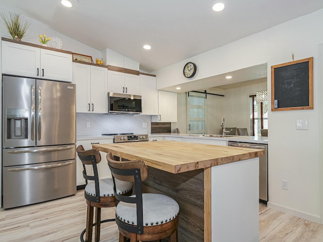 1732 Sunrise Ln, Sebastian, FL 32958 - kitchen featuring butcher block counters, a breakfast bar area, and stainless steel appliances