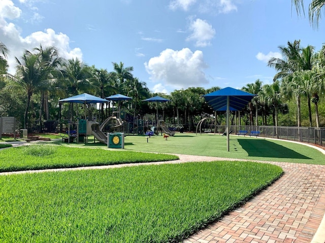 community play area featuring a lawn and fence