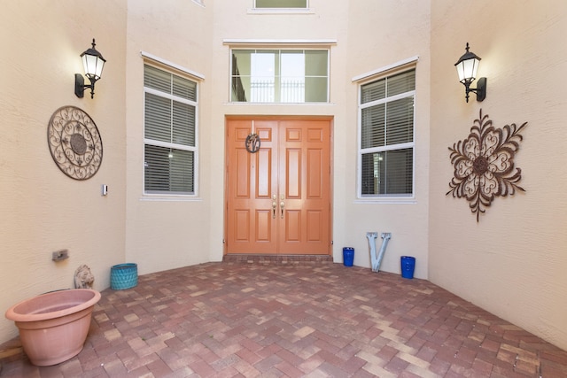 entrance to property featuring a porch and stucco siding