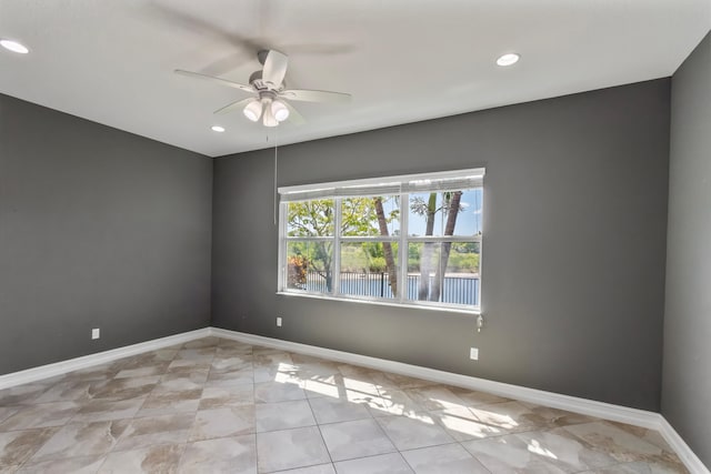 empty room with recessed lighting, a ceiling fan, and baseboards