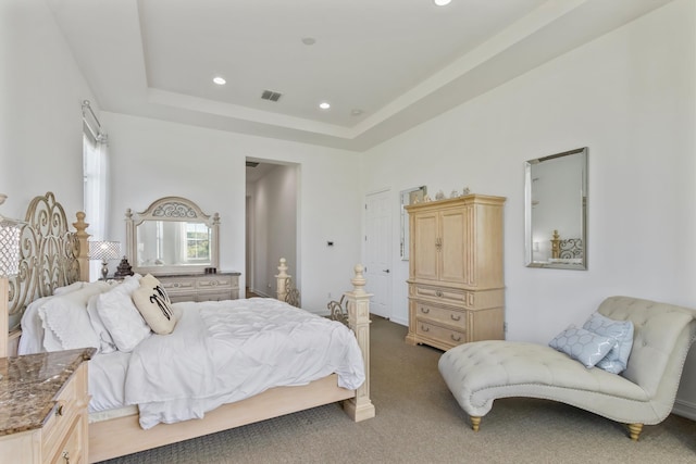 carpeted bedroom featuring recessed lighting, visible vents, and a tray ceiling