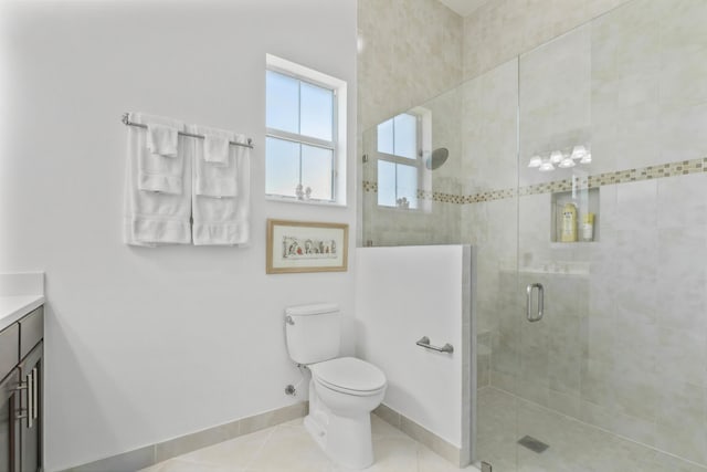 bathroom featuring vanity, tile patterned floors, toilet, a stall shower, and baseboards