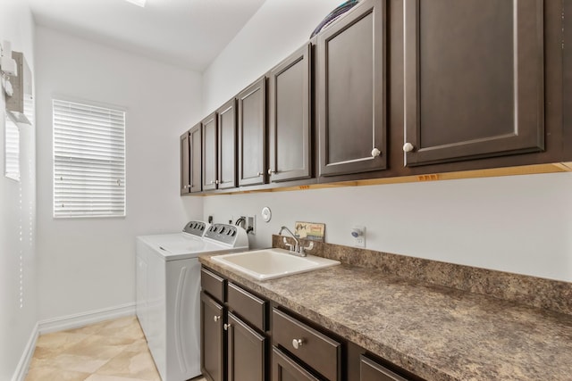 laundry area with washer and dryer, a sink, cabinet space, and baseboards