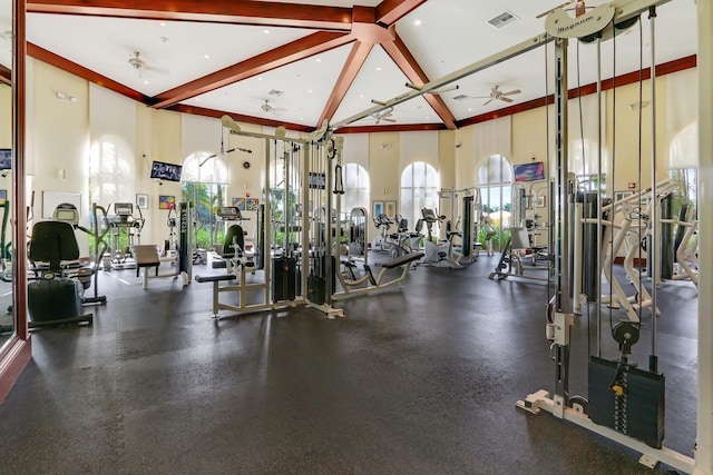 workout area featuring visible vents, a ceiling fan, and a towering ceiling