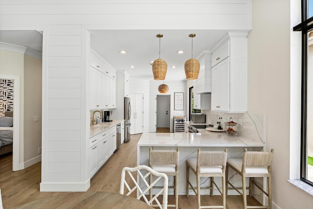 2441 NW 64th St, Boca Raton, FL 33496 - kitchen featuring decorative backsplash, a peninsula, appliances with stainless steel finishes, and light wood-type flooring
