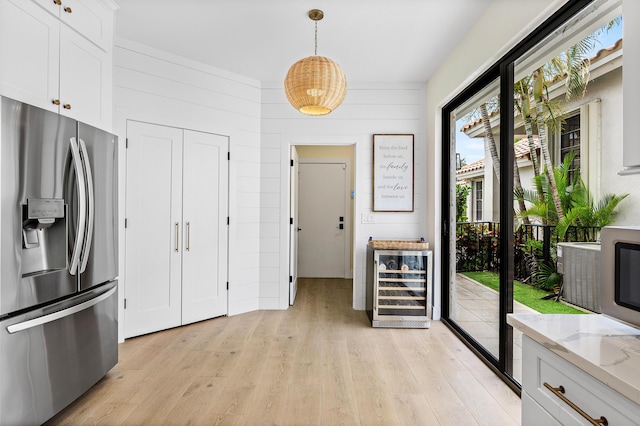 2441 NW 64th St, Boca Raton, FL 33496 - kitchen with light wood-type flooring, stainless steel fridge with ice dispenser, white cabinetry, light stone countertops, and wine cooler