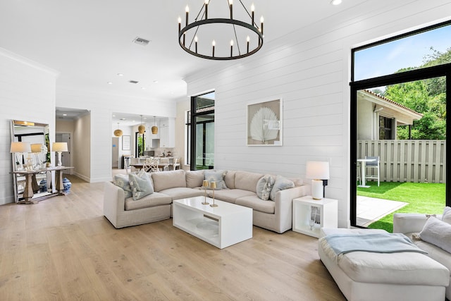 2441 NW 64th St, Boca Raton, FL 33496 - living area featuring wooden walls, light wood-style flooring, and crown molding