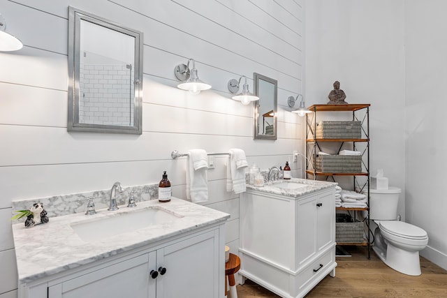 2441 NW 64th St, Boca Raton, FL 33496 - bathroom with two vanities, wood finished floors, a sink, and toilet