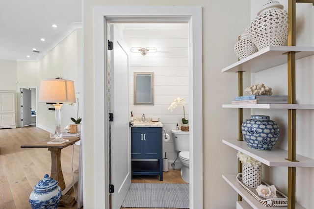 2441 NW 64th St, Boca Raton, FL 33496 - half bath featuring wood finished floors, visible vents, toilet, vanity, and ornamental molding