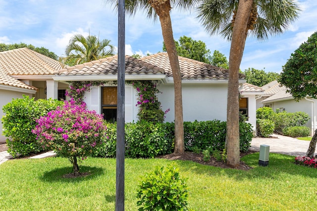 2441 NW 64th St, Boca Raton, FL 33496 - view of home's exterior featuring a lawn, a tiled roof, and stucco siding