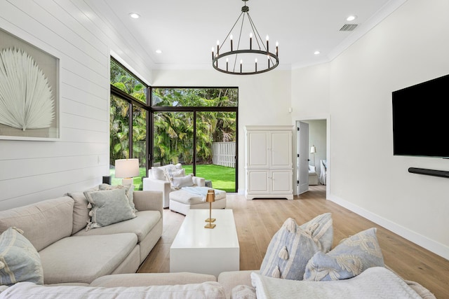 2441 NW 64th St, Boca Raton, FL 33496 - living room featuring an inviting chandelier, visible vents, light wood-style floors, crown molding, and baseboards