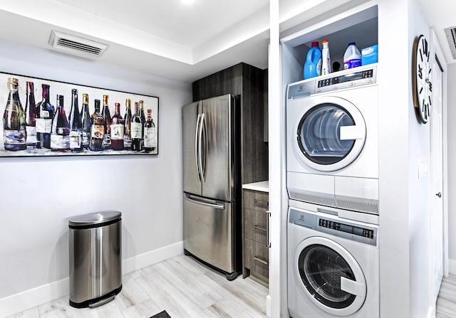 2400 Presidential Way Unit 1803, West Palm Beach, FL 33401 - laundry area with stacked washer and clothes dryer and baseboards