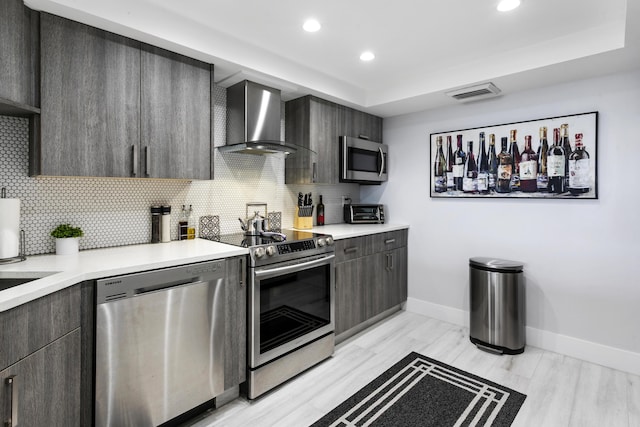 2400 Presidential Way Unit 1803, West Palm Beach, FL 33401 - kitchen with wall chimney range hood, appliances with stainless steel finishes, baseboards, decorative backsplash, and recessed lighting