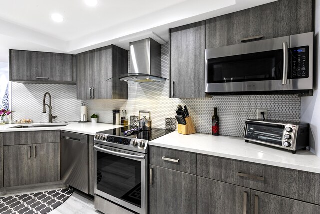 2400 Presidential Way Unit 1803, West Palm Beach, FL 33401 - kitchen featuring appliances with stainless steel finishes, wall chimney range hood, a sink, and light countertops