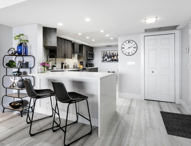 2400 Presidential Way Unit 1803, West Palm Beach, FL 33401 - kitchen featuring a sink, light countertops, modern cabinets, a kitchen breakfast bar, and baseboards