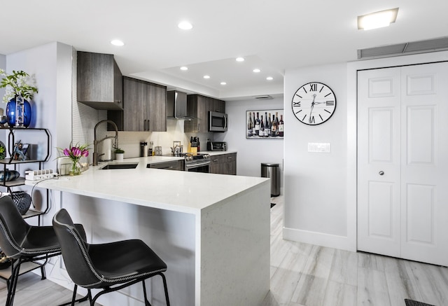 2400 Presidential Way Unit 1803, West Palm Beach, FL 33401 - kitchen with modern cabinets, light countertops, a kitchen breakfast bar, stainless steel appliances, and wall chimney exhaust hood