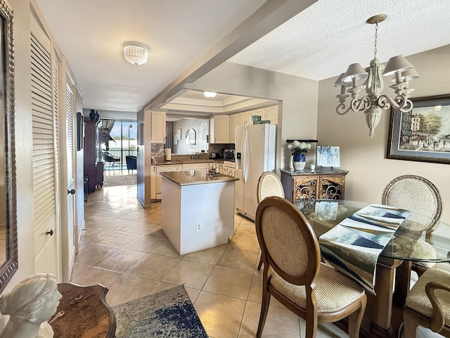 777 S Federal Hwy Unit 209N, Pompano Beach, FL 33062 - kitchen with light tile patterned floors, white fridge with ice dispenser, a sink, black microwave, and an inviting chandelier