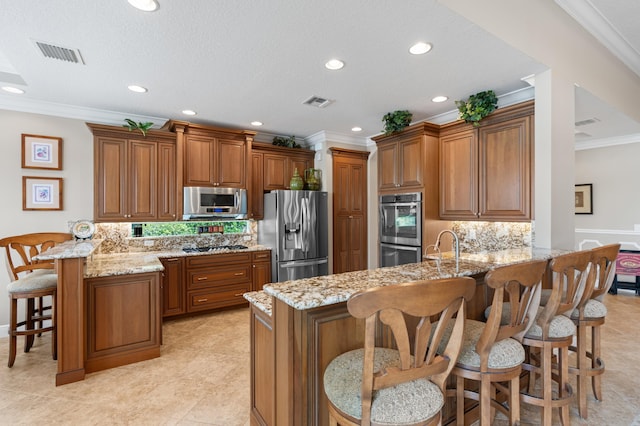 725 Edgebrook Ln, West Palm Beach, FL 33411 - kitchen with brown cabinets, appliances with stainless steel finishes, a peninsula, visible vents, and ornamental molding