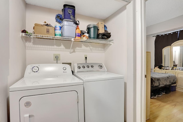 washroom featuring washer and clothes dryer and light wood-style flooring