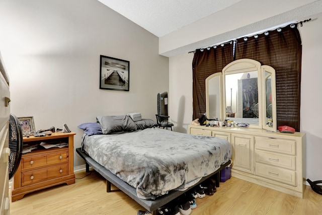 bedroom featuring light wood-style floors and baseboards