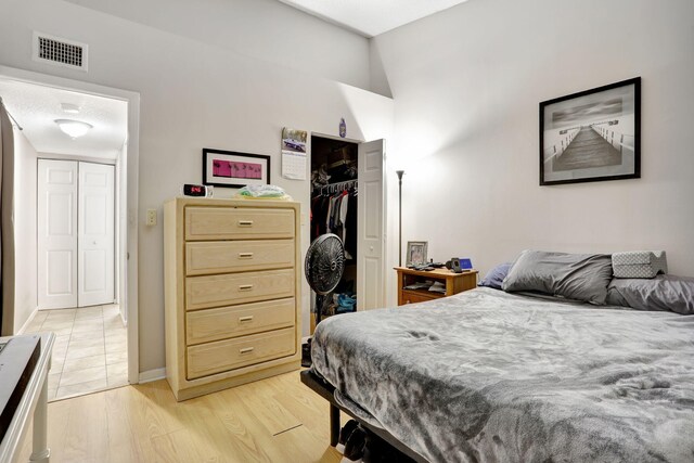 621 Lyons Rd Unit 9201, Coconut Creek, FL 33063 - bedroom featuring a closet, visible vents, light wood-style flooring, and baseboards