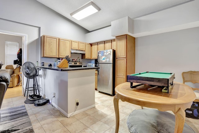 kitchen featuring light brown cabinetry, dark countertops, stainless steel appliances, a peninsula, and under cabinet range hood