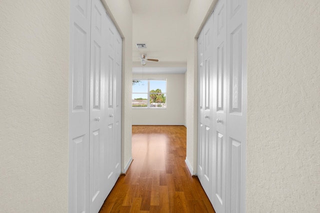 3030 Grandiflora Dr, Greenacres, FL 33467 - hallway with a textured wall, visible vents, and dark wood-style floors