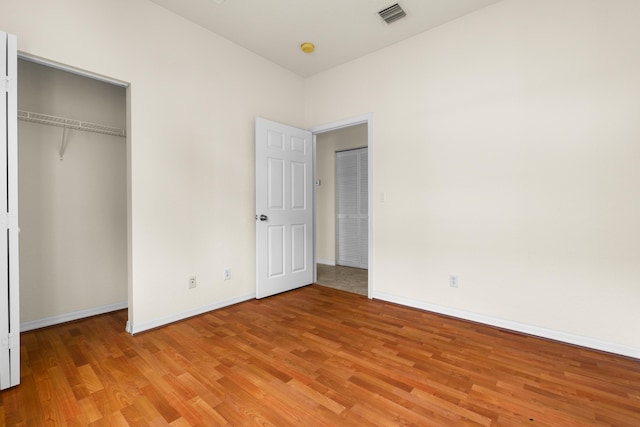 3030 Grandiflora Dr, Greenacres, FL 33467 - unfurnished bedroom with baseboards, light wood-style flooring, visible vents, and a closet