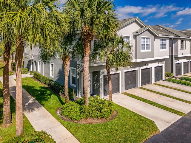3030 Grandiflora Dr, Greenacres, FL 33467 - view of front facade with a front lawn, an attached garage, concrete driveway, and stucco siding
