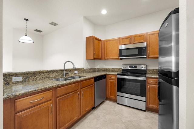 3030 Grandiflora Dr, Greenacres, FL 33467 - kitchen with a sink, dark stone counters, appliances with stainless steel finishes, brown cabinetry, and light tile patterned floors