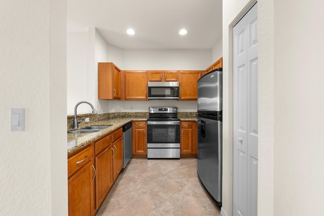 3030 Grandiflora Dr, Greenacres, FL 33467 - kitchen featuring light stone counters, a sink, brown cabinetry, stainless steel appliances, and recessed lighting