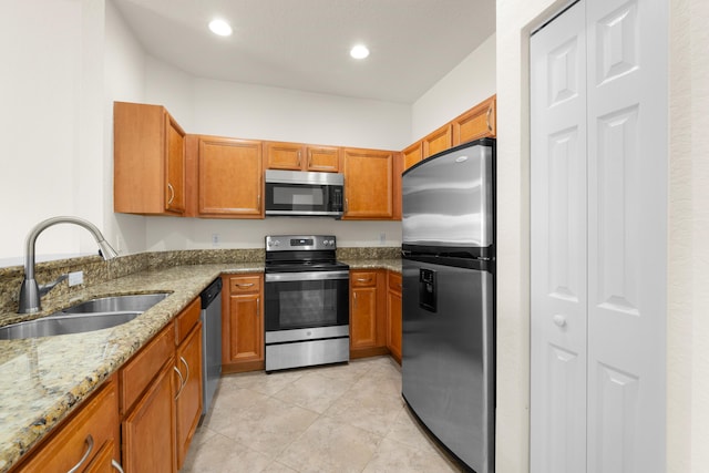 3030 Grandiflora Dr, Greenacres, FL 33467 - kitchen with light stone counters, a sink, brown cabinets, and appliances with stainless steel finishes